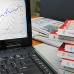 Financial books with laptop showing graphs and charts. Camera focus on graph. For concepts such as business and finance, internet and technology, and stock analysis and financial investment.